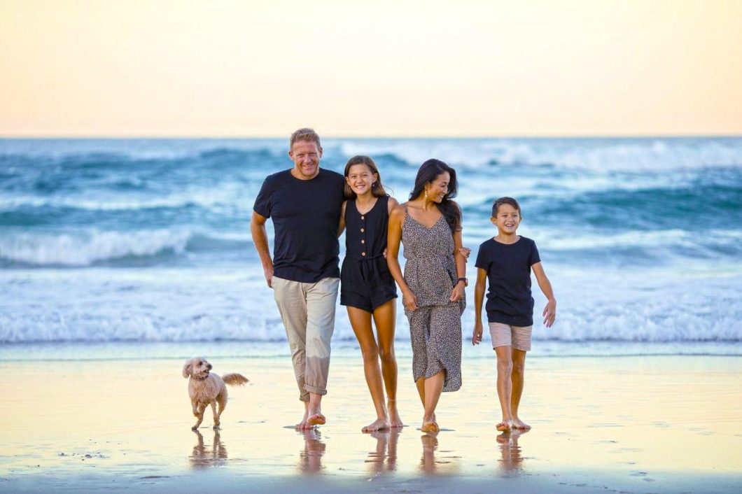 Une famille unie et heureuse se promène sur la plage