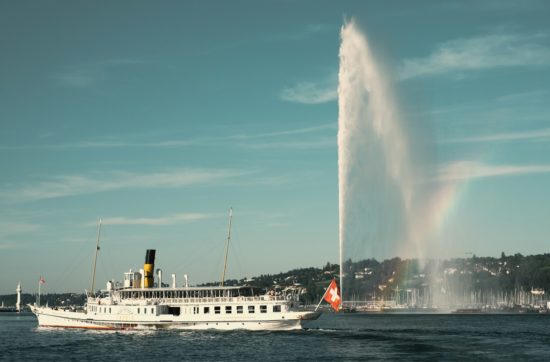 white ship on water fountain under blue sky during daytime
